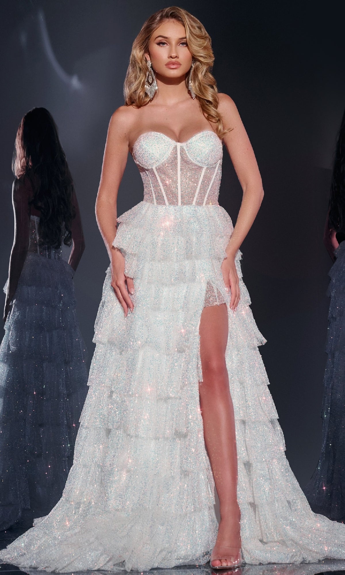 A woman in the Jovani Strapless Long Lilac Ruffle Prom Gown 38165, featuring a sweetheart neckline and tiered ruffle skirt, stands before a dark background, her sparkling look perfect for prom.